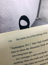 Load image into Gallery viewer, Sukun Arabic diacritic black metal bookmark in a book