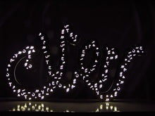 Load image into Gallery viewer, 1m long Ramadan decoration in brushed stainless steel, 3D free standing light sign of the term "Ramadan" in Arabic calligraphy. light on in dark view
