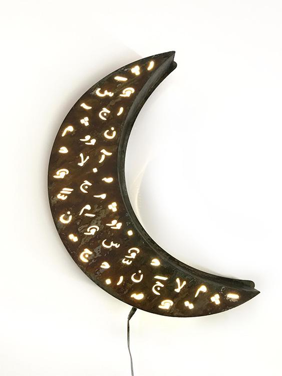 Crescent ramadan wall light in rusted metal with laser cut design of Arabic diacretics. 