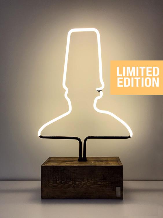 A sufi shoulders & hat shape glass neon table light on a wooden base.